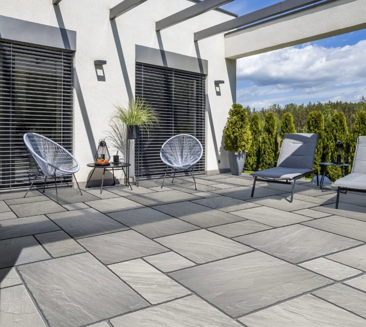 Modern outdoor terrace finished with grey natural stone paving